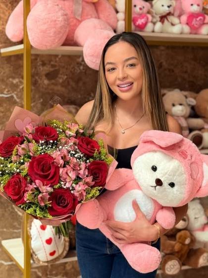 Cliente da Floricultura Pétalas recebendo buquê de rosas vermelhas