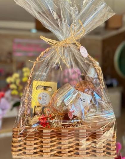 Cesta de presente com chocolates embrulhada em celofane